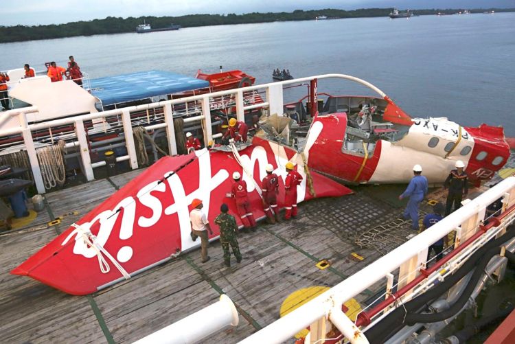 Crew members of a recovery ship prepare to unload the tail section of AirAsia Flight 8501 at Kumai port in Pangkalan Bun, Central Borneo, Indonesia, on Jan. 11. The National Transportation Safety Committee says an analysis of Flight 8501's data recorder showed that the Airbus A320 had problems with its rudder control system while flying between the Indonesian city of Surabaya and Singapore on Dec. 28. The Associated Press