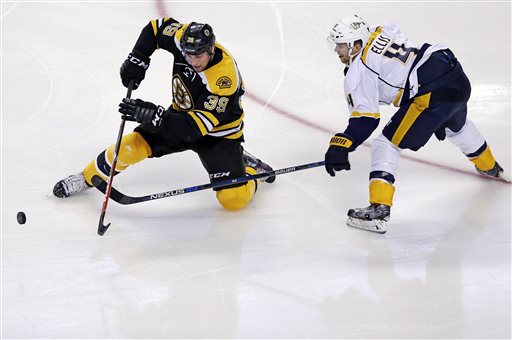 Boston Bruins left wing Matt Beleskey (39) tries to knock the puck away from Nashville Predators defenseman Ryan Ellis (4). (AP Photo/Charles Krupa)