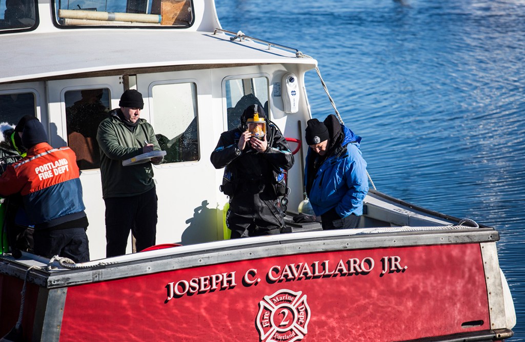 Portland Fire and Police department support personnel assist divers searching the waters for James Dyer near Union Wharf on Tuesday. Whitney Hayward/Staff Photographer
