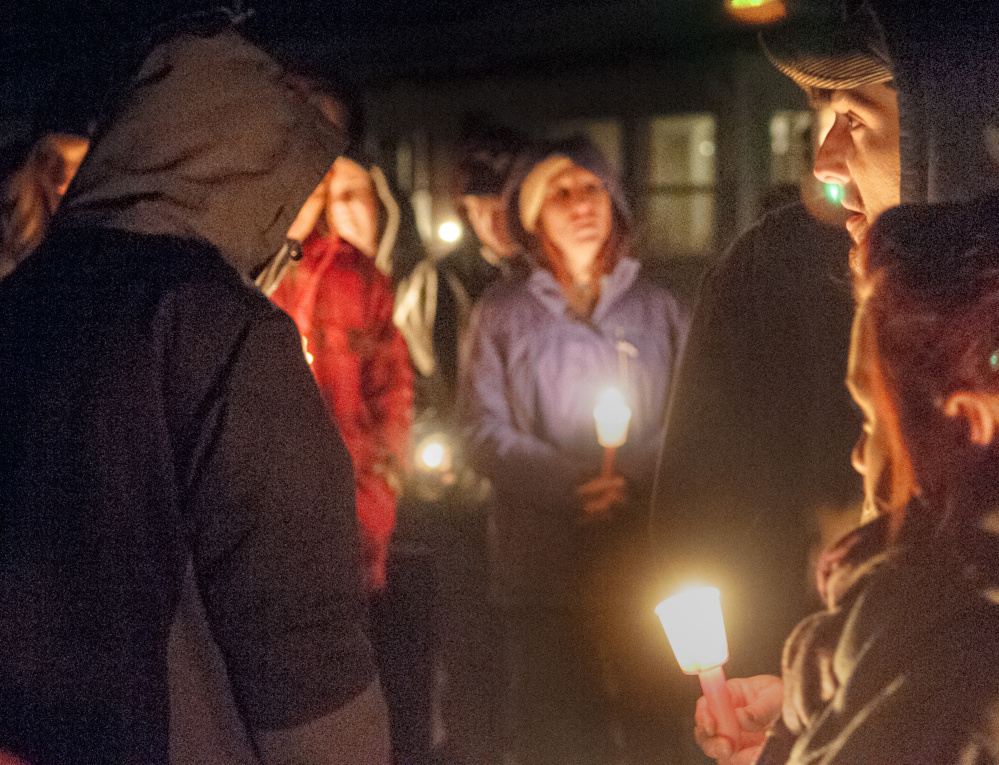 David Jordan, top right, leads The Lord’s Prayer during a candlelight vigil Friday in Augusta in remembrance of Eric Williams, 35 and Bonnie Royer, 26, who were shot to death early Christmas morning in Manchester.
