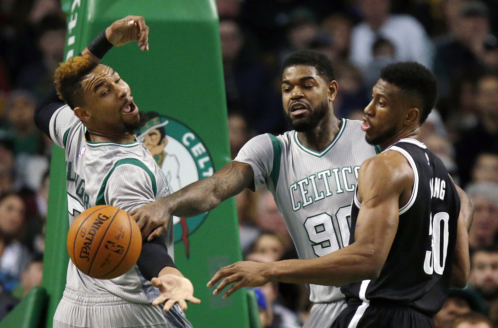 Boston’s Jared Sullinger, left, and Amir Johnson (90) and Brooklyn’s Thaddeus Young battle for the ball Saturday in Boston.