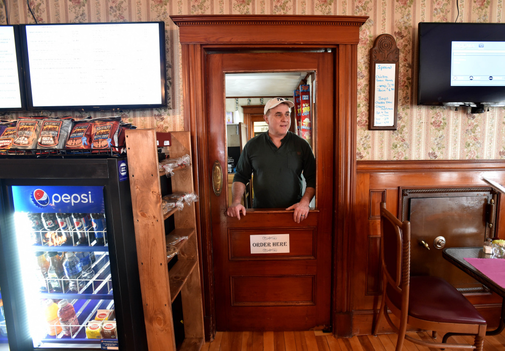 Mike Pelletier, owner of M&M’s Ice Cream Parlor and Fireside Cafe on Main Street in Madison waits to take an order on Thursday. He and his wife, Mary Jane, opened the business in November and are looking forward to a great 2016, he said.