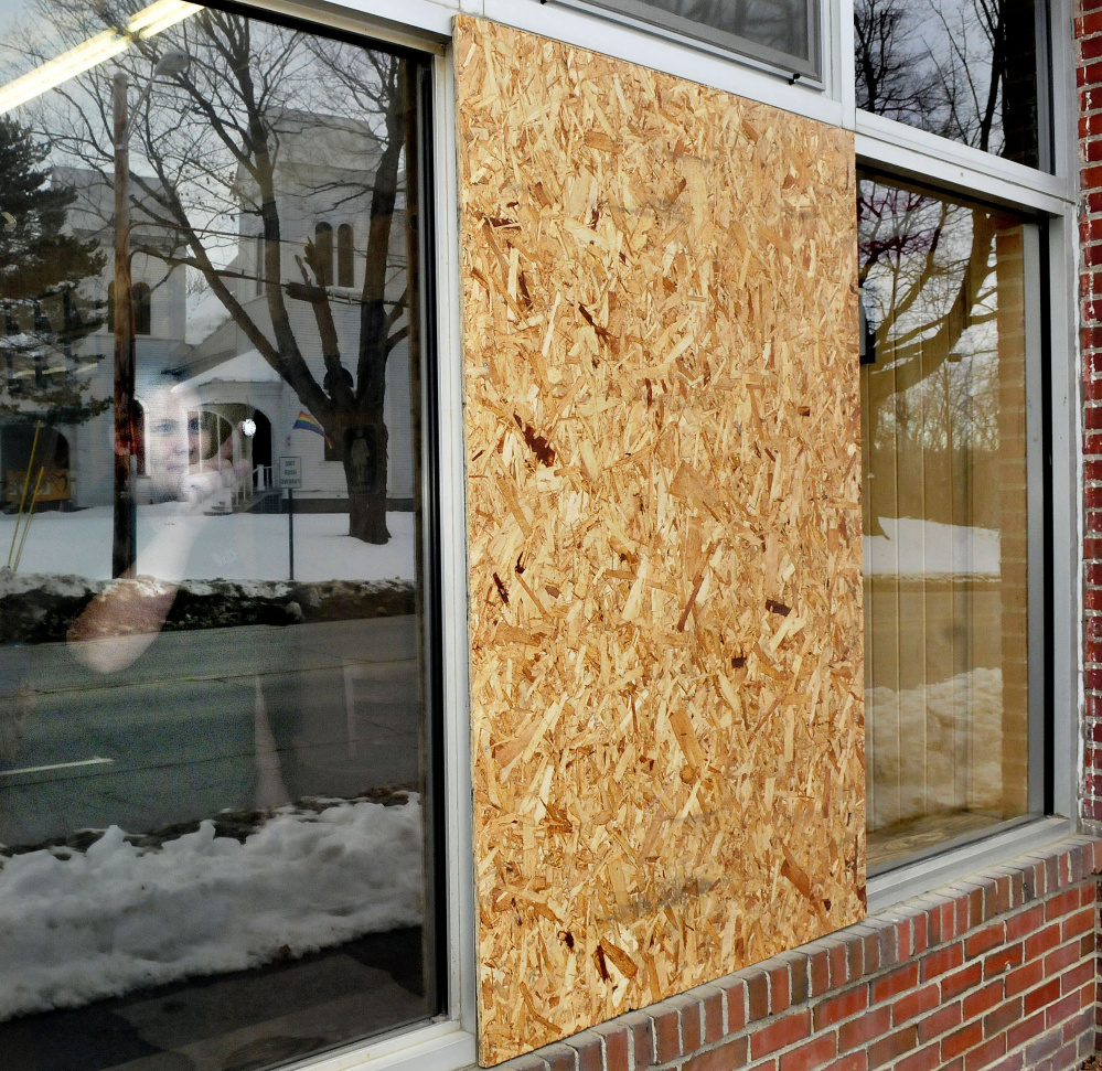 Standing beside a boarded-up window inside Dysart’s Travel Stop store in Pittsfield on Sunday, employee Nicole Smith points to one of four holes made by vandals with a pellet gun since late last week.