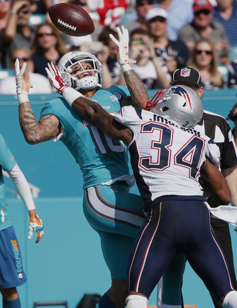 Miami Dolphins wide receiver Kenny Stills (10) is unable to hold onto a pass as New England Patriots cornerback Leonard Johnson (34) defends during the first half Sunday in Miami Gardens, Florida.