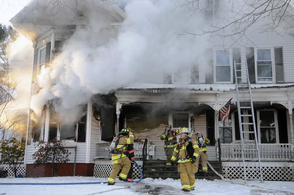 Firefighters scramble to contain a blaze Wednesday inside a residence on 37 Riverview Drive in Gardiner. The home was heavily damaged by fire and smoke, firefighters said.