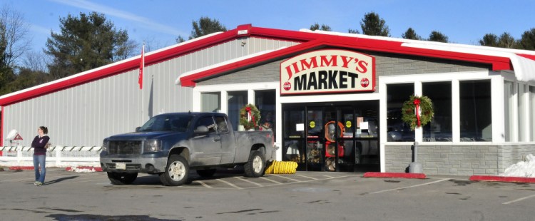 An employee stands outside Jimmy’s Market in Bingham as large fans ventilate the building that was closed Wednesday because of a fire ignited by a spark from a cutting torch.