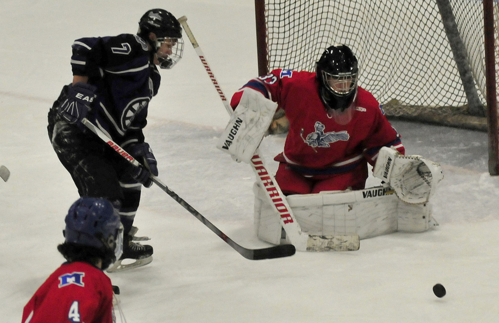 Messalonskee goalie Eli Michaud deflects a shot by Waterville’s Nick Denis during a Class B North game Wednesday night at Sukee Arena in Winslow.