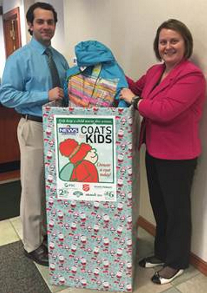 Anthony Sementelli, a seasonal teller, and Susan Albert, a teller in Waterville, with a coat that was dropped off at the Waterville branch.