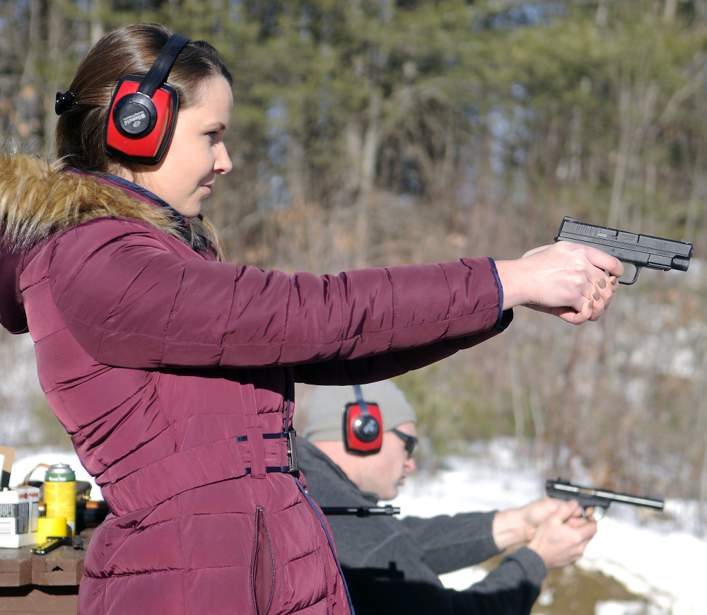 Katherine Pollock fires a pistol with Rob Sibley on Wednesday at an Inland Fisheries and Wildlife range in Augusta. Sibley said he doesn’t agree with President Obama’s executive actions to order more background checks on guns purchases. “But I think his heart is in the right place,” the Augusta resident said. A Richmond native who lives in Connecticut, Pollock said she wants to learn how to shoot.