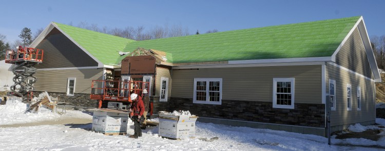 Kavestone LLC builders work Wednesday on the exterior of the new Belgrade Town Office, which is scheduled to open in the spring.