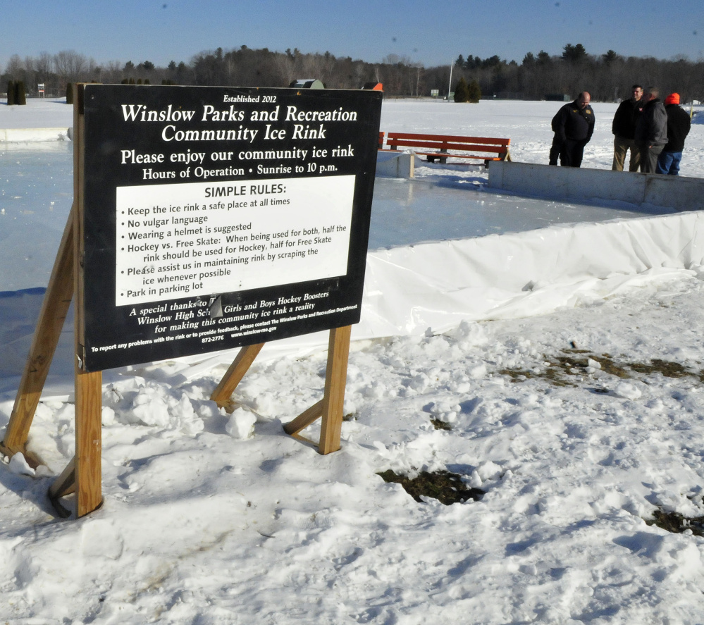 Contributors talk about creating an outdoor ice skating rink in Winslow Thursday. The rink opens Saturday.