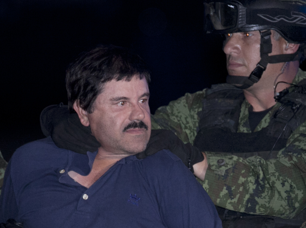 Joaquin “El Chapo” Guzman is made to face the press as he is escorted to a helicopter in handcuffs by Mexican soldiers and marines at a federal hangar in Mexico City, Mexico, Friday.
