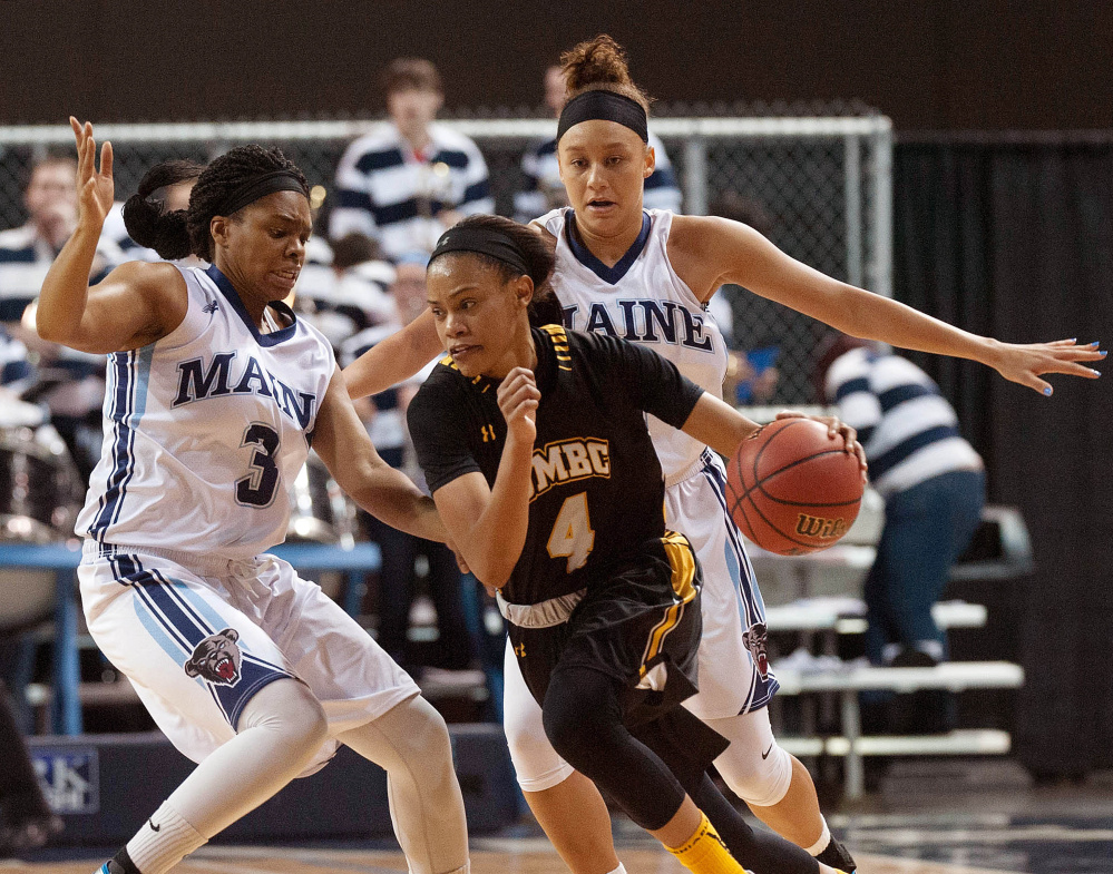 UMaine women’s basketball players Bella Swan (5) right, and Chantel Charles (3) put the brakes on UMBC guard Taylor McCarly (4) in the second half of their America East game at the Cross Insurance Center in Bangor, Maine on Saturday, Jan. 10, 2016. (Michael C. York/Special to the Telegram)