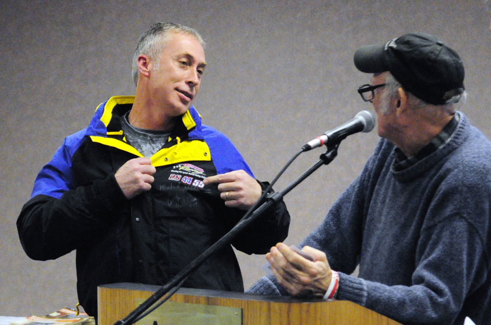 Retired professional stock car racer Andy Santerre, left, models a jacket autographed by him and two other professional drivers that Rosey Gerry is about to auction off Saturday at the Augusta Civic Center. The event was a fundraiser for the Maine Vintage Race Car Association.