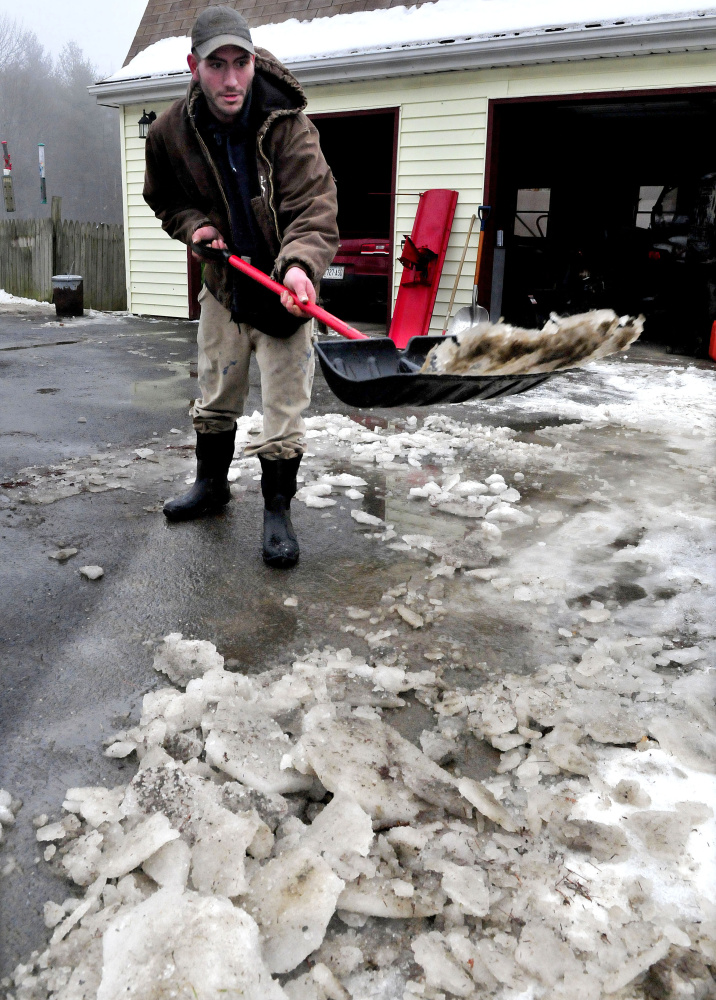 OAKLAND,  ME-  January 10: James Gray throws slush and chunks of ice  that melted on the driveway at his home in Oakland on a warm and rainy Sunday, January 10, 2016.  (Photo by David Leaming/Staff Photographer)