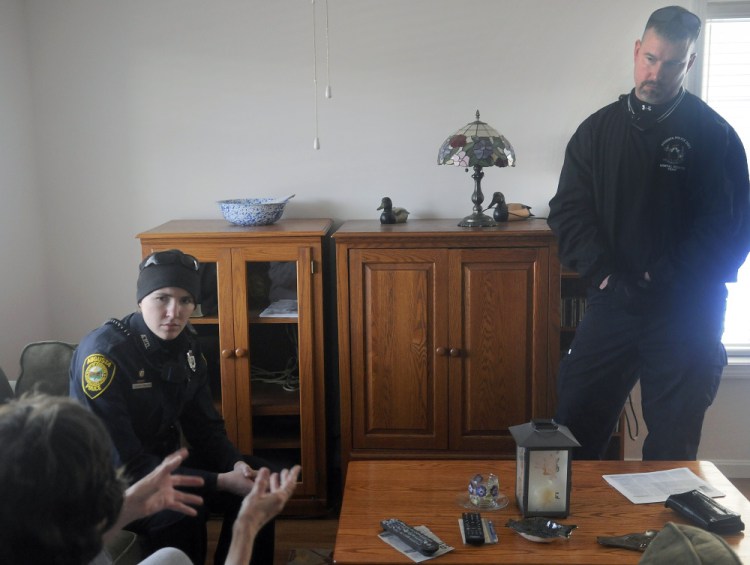 Augusta Police Officer Laura Drouin, left, and crisis worker Greg Smith help a resident of the city as part of efforts to provide crisis services.