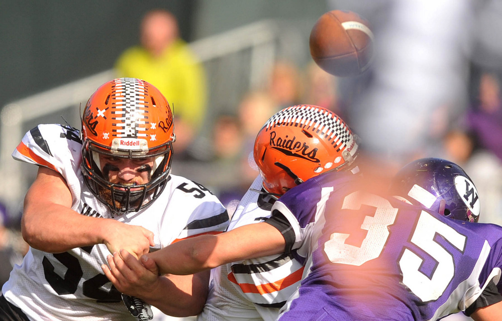 Winslow’s Alec Clark (54) and teammate Patrick Hopkins, center, break up a pass intended for Waterville’s Devon Begin during a Big Ten Conference game this season. Clark was named a finalist for the Frank J. Gaziano award on Monday.