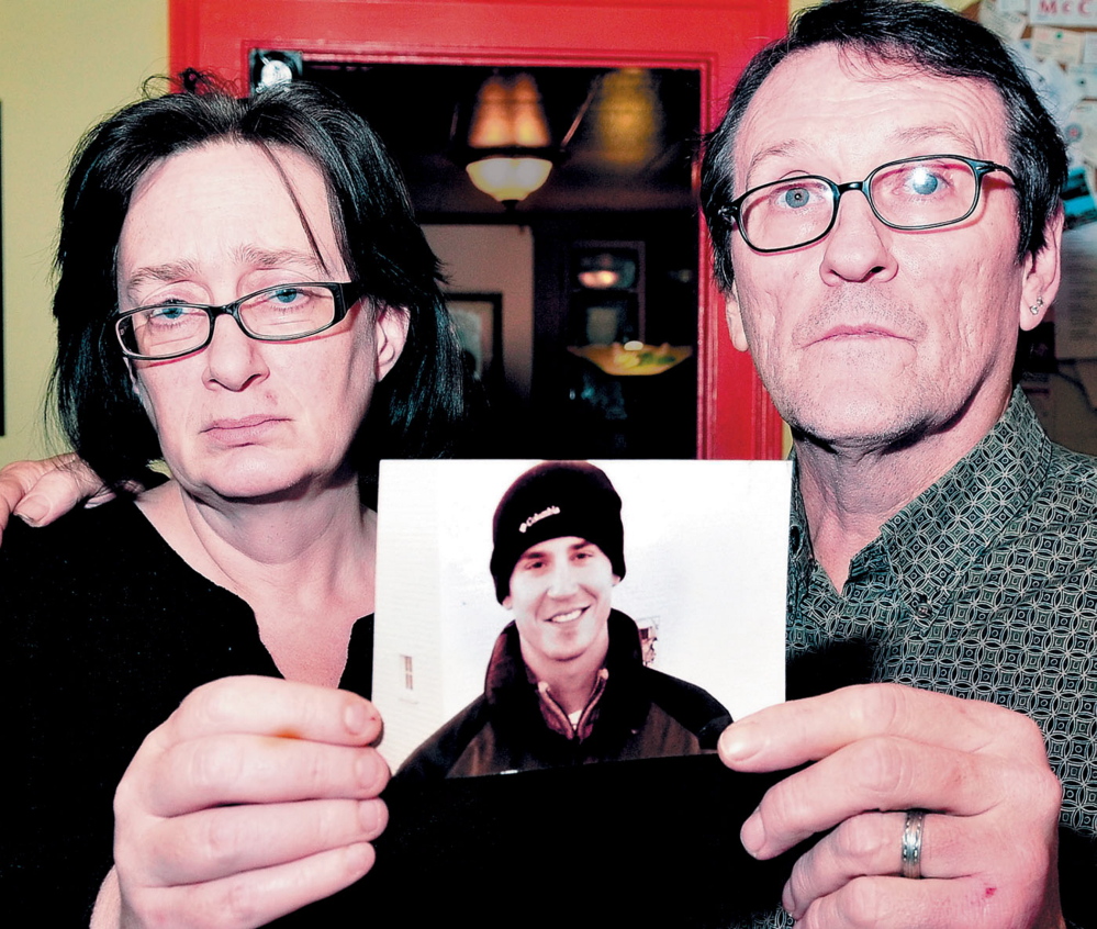 Lorna and Michael Smilek hold a 2006 photograph of Michael’s son Justin Crowley-Smilek, who was shot and killed after he confronted Farmington police.