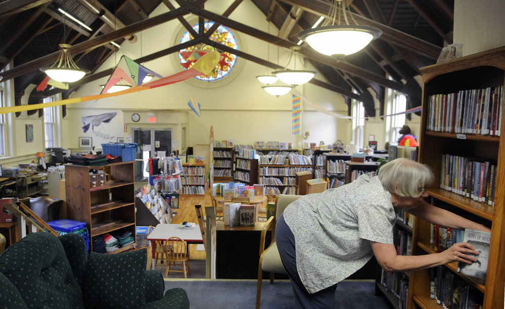 Gardiner Public Library teenage librarian Ginni Nichols sorts books in the children’s reading room in this September 2015 file photo.