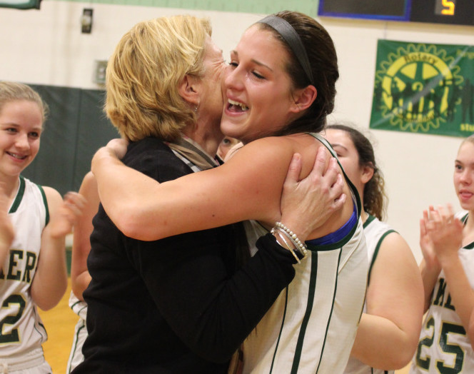 Rangeley senior Blayke Morin, right, receives a congratulatory hug from coach Heidi Deery after Morin scored her 1,000th career point in an East/West Conference girls basketball game against Buckfield on Friday.