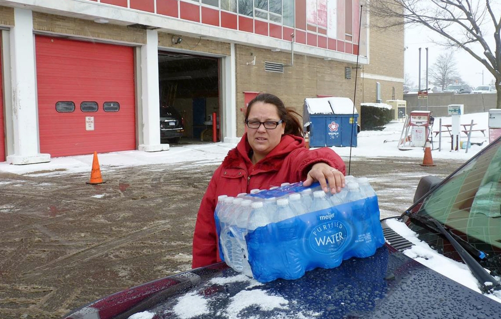 Rabecka Cordell picks up a case of bottled water outside the fire station in Flint, Michigan. “We both have lead poisoning,” said Cordell, who learned that two weeks ago from her doctor. She says she has leukemia and her son has learning and speech disabilities. She will not even bathe in Flint water and won’t wash her son in it.