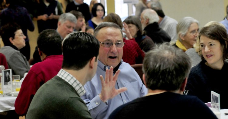Gov. Paul LePage gestures while speaking with Waterville Mayor Nick Isgro and Sharon Corwin during the 30th annual Martin Luther King Jr. breakfast event at the Muskie Center in Waterville on Monday.