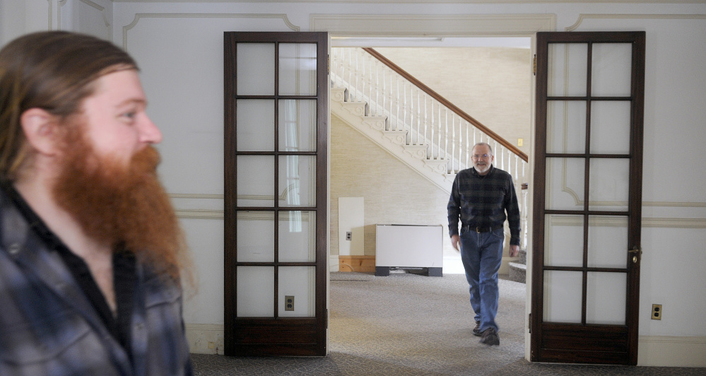 Tyler Quist, left, and his father, David, explore the Gannett House in Augusta Tuesday during an announcement by the heirs of publisher Guy Gannett that the former state office building will be converted into a First Amendment museum. Tyler Quist, of Freeport, is Gannett’s great grandson.