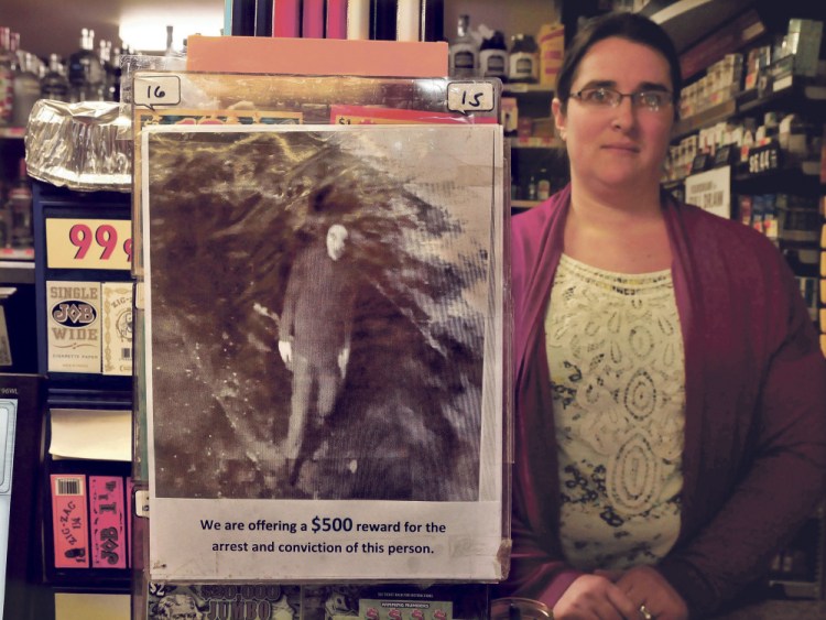 Kate Anton holds up the security camera photo on Tuesday of the person who owners of the Corner Store in Athens, where she is manager, believe attempted to break in over the weekend. Jim’s Variety in Athens was also broken into and both stores have posted the photo on their Facebook pages.
