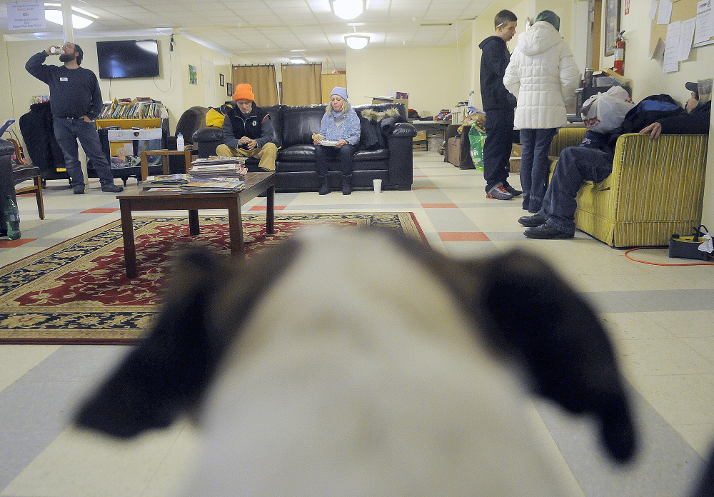 Guests, a dog and volunteers eat and warm up Tuesday at the Augusta Community Warming Center on a day when the temperature was 14 degrees.
