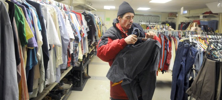 James Larrabee collects clothes in Addie’s Attic Tuesday next to the Augusta Community Warming Center in Augusta.
