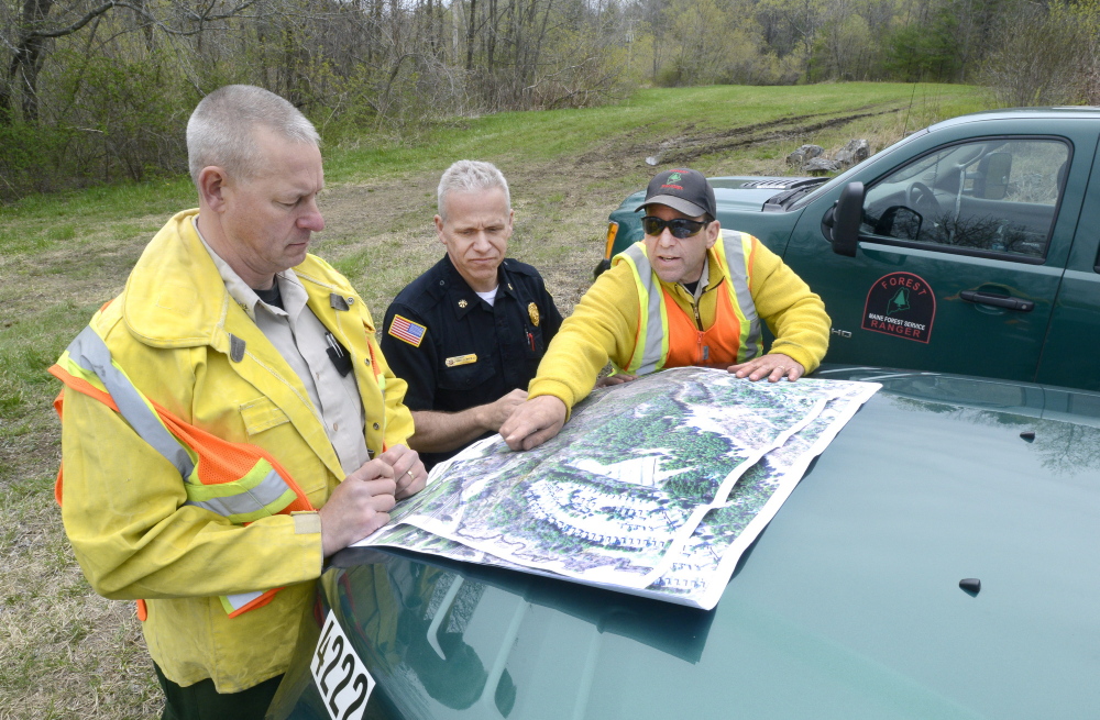 Mark Rousseau (left), a forest ranger and Phillips deputy fire chief, joins ranger John Leavitt (right) and Saco Fire Department Deputy Chief Robert Martin at a train fire in Saco in 2014. Rousseau will be interim fire chief in Phillips after Stephen Naas, who became chief Jan. 1, resigned last week. Fourteen of the towns 17 volunteer fire fighters had said they would resign after Naas was hired.