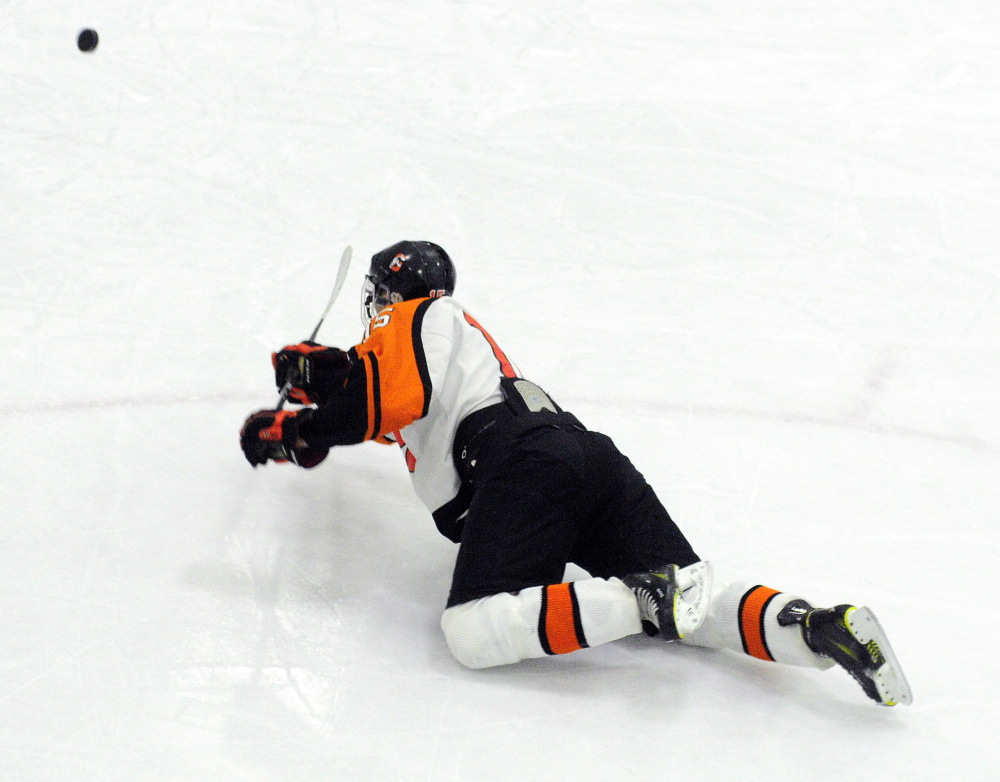 Logan Peacock falls down but still scores his fourth goal of the game that put the Tigers up 5-0 over Massabesic/Bonny Eagle/Old Orchard on Wednesday at Camden National Bank Ice Vault in Hallowell.