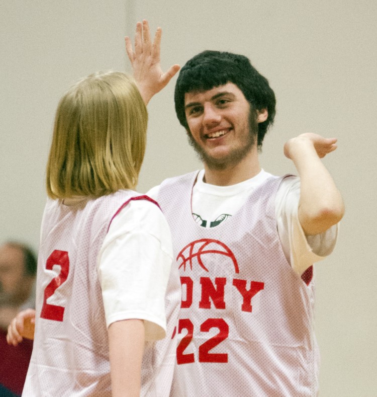 Cony’s Katrina Boisbert, left, high fives teammate Ethan MacGregor after he scored a basket during a unified basketball game against Winthrop on Friday at Cony High in Augusta.