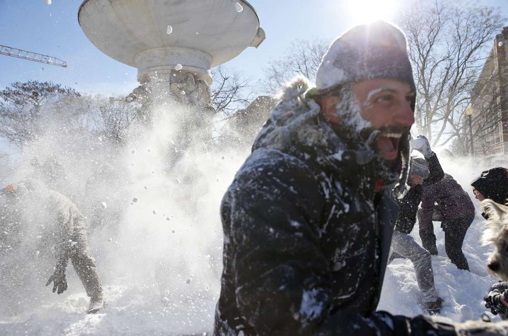 A man runs away covered in snow Sunday during an organized snowball fight at Dupont Circle in Washington.
