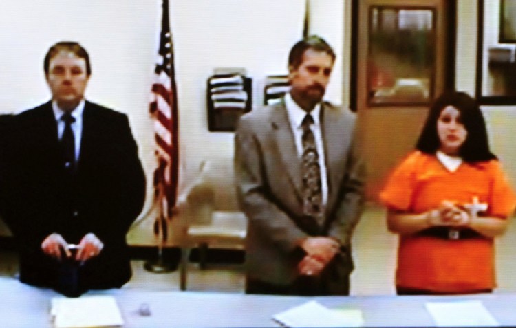 Defendant Kayla Stewart appeared in a video during a hearing at the Skowhegan District Court on a charge of murder in connection with the death of her newborn son found by police at her home in Fairfield. Next to Stewart is her attorney, Phillip Mohlar, and at left is state attorney Brent Davis.