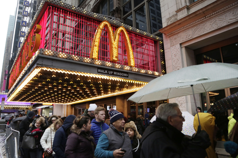 In this Tuesday, Dec. 29, 2015, photo, pedestrians pass under a McDonald’s marquee in New York. McDonald’s reports quarterly financial results, Monday.
