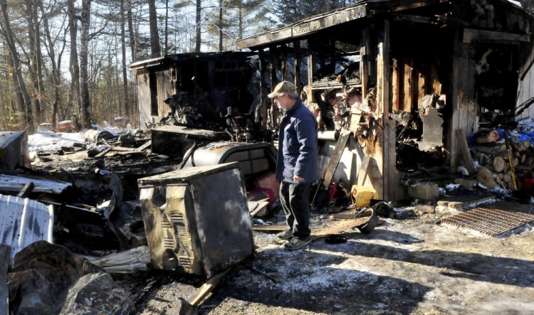Maurice Bowring on Monday looks over the dryer that investigators determined was the source of fire that destroyed his home in Norridgewock last week.