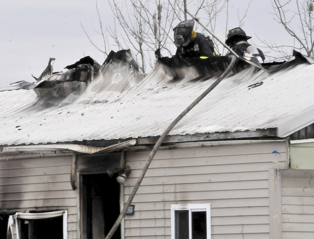 Firefighters can be seen extinguishing fire that ripped a hole in the roof of a mobile home in Athens Tuesday morning.