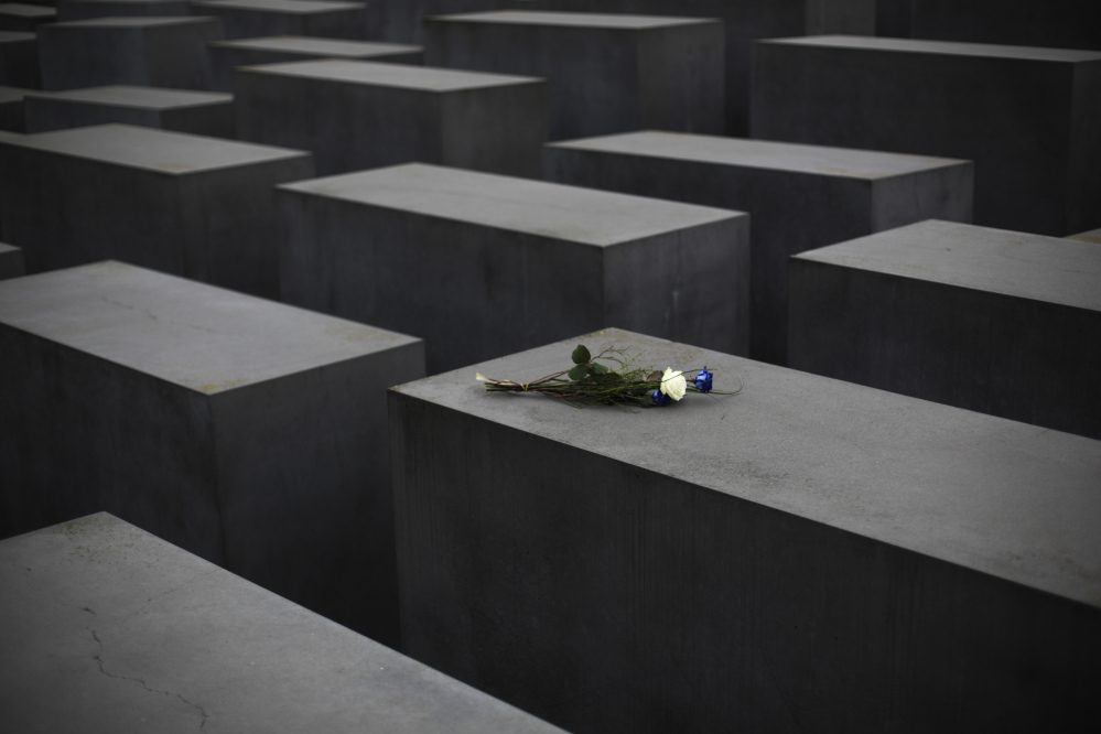 Flowers lay on a slab of the Holocaust Memorial to commemorate the victims of the Nazi regime at the International Holocaust Remembrance Day in Berlin, Wednesday.