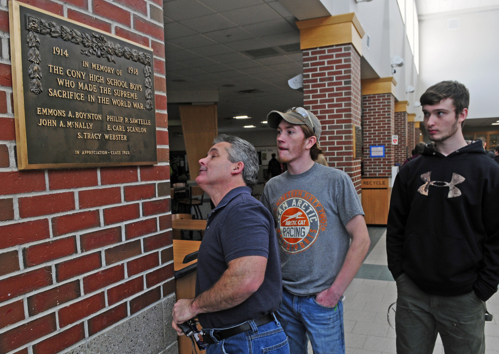 Machine tools instructor Darryl Nadeau, left, looks at the World War I memorial plaque that two of his students Colt Seigars and Mathew Musselman (cq) made brackets for on Tuesday in the Cony High School food court.
