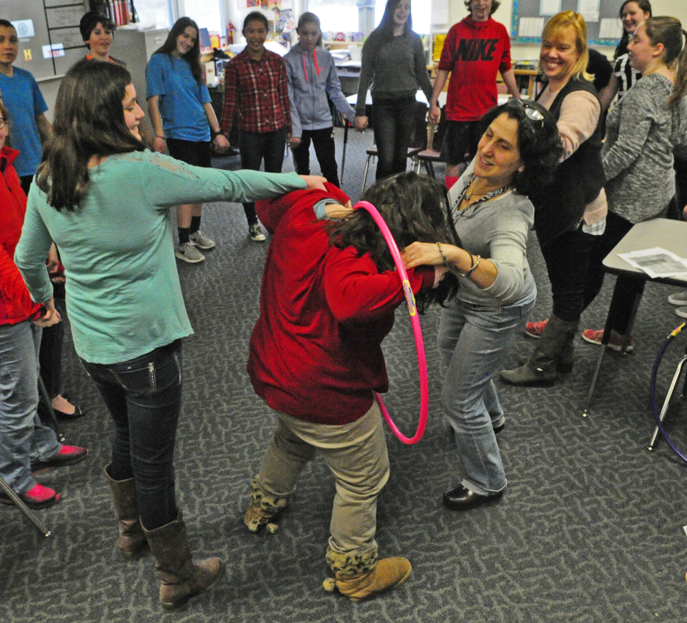 Students and staff participate in an activity where they had to move a hula hoop around the circle while still holding hands during Healthy Decisions Day events on Friday at Maranacook Community Middle School in Readfield.