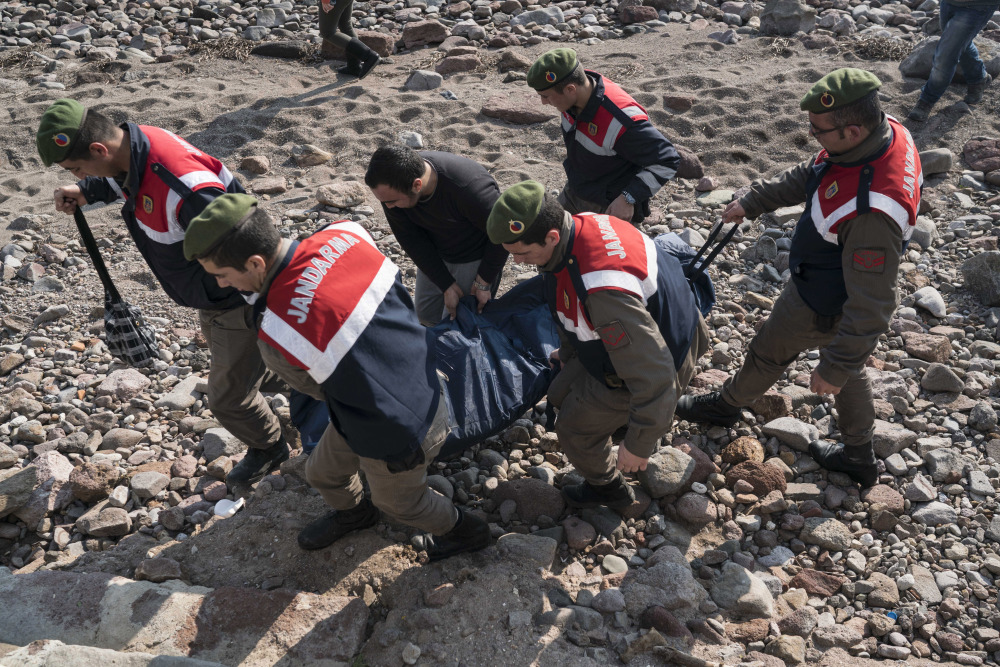 Turkish paramilitary police officers carry the dead body of a migrant from the beach near the Aegean town of Ayvacik, Canakkale, Turkey, Saturday.