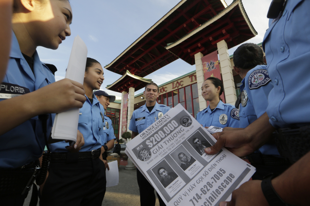 Westminster teenage police volunteers fan out along the strip of Vietnamese restaurants and shops known as “Little Saigon” to tell storekeepers about the escaped inmates and urge them to post fliers with their pictures to spread the word in Westminster, Calif.