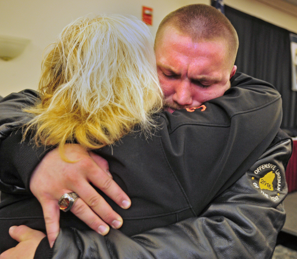 Terri Clark, left, hugs her son, Winslow High School senior Alec Clark, after he won the Frank J. Gaziano Offensive Lineman Award on Saturday at the Augusta Civic Center.
