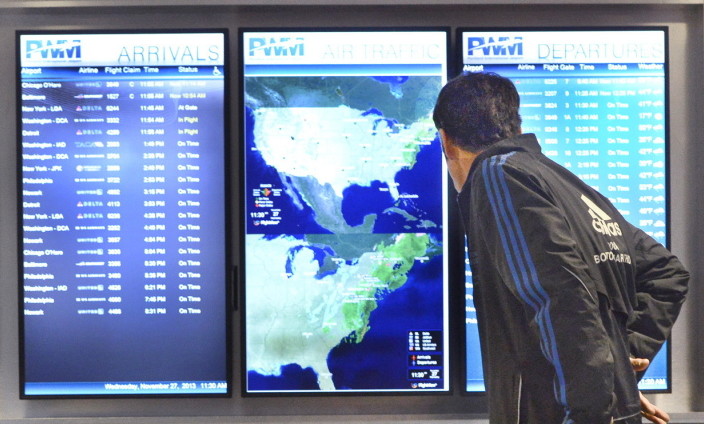 A passenger checks the flight schedule at the Portland International Jetport. Even if there is no snow in Maine, it's unlikely all flights will come and go as planned Friday and Saturday, particularly those that pass through Washington, D.C., and Baltimore. 