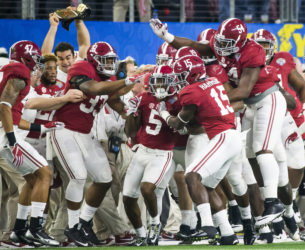 Alabama defensive back Cyrus Jones (5) is mobbed by teammates after intercepting a pass in the end zone during the first half of the Cotton Bowl on Thursday night in Arlington, Texas.