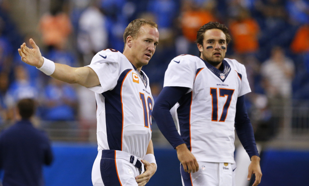 Denver Broncos quarterbacks Peyton Manning and Brock Osweiler get ready for a game against the Detroit Lions in Detroit on Sept. 27.