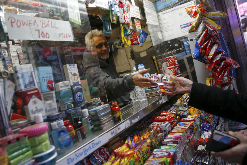 A vendor sells a ticket for the $700 million Powerball lottery draw at Times Square in New York on Thursday. The drawing will be held Saturday.