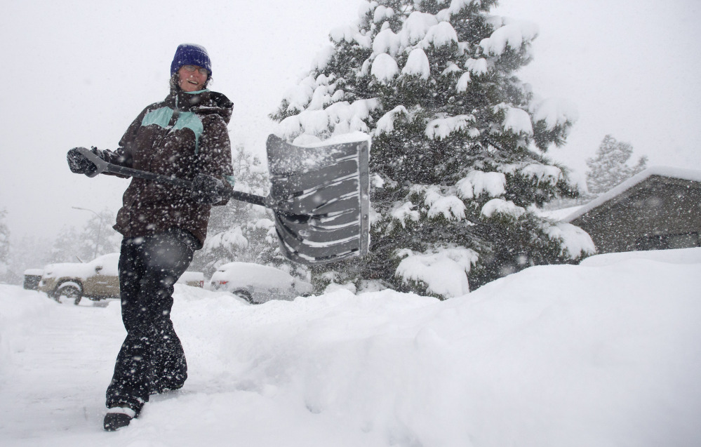 Jennifer Corrigan shovels snow in her driveway in Flagstaff, Ariz., on Thursday. El Nino-fueled storms also brought heavy snow to northern Arizona. Meteorologists say powerful climactic forces are at work this winter.