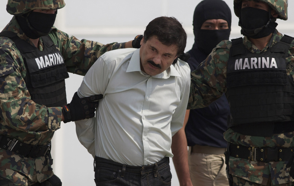 Joaquin “El Chapo” Guzman is escorted to a helicopter in handcuffs by Mexican navy marines at a hangar in Mexico City in 2014. Mexican President Enrique Pena Nieto posted on his Twitter account Friday that Guzman was recaptured.